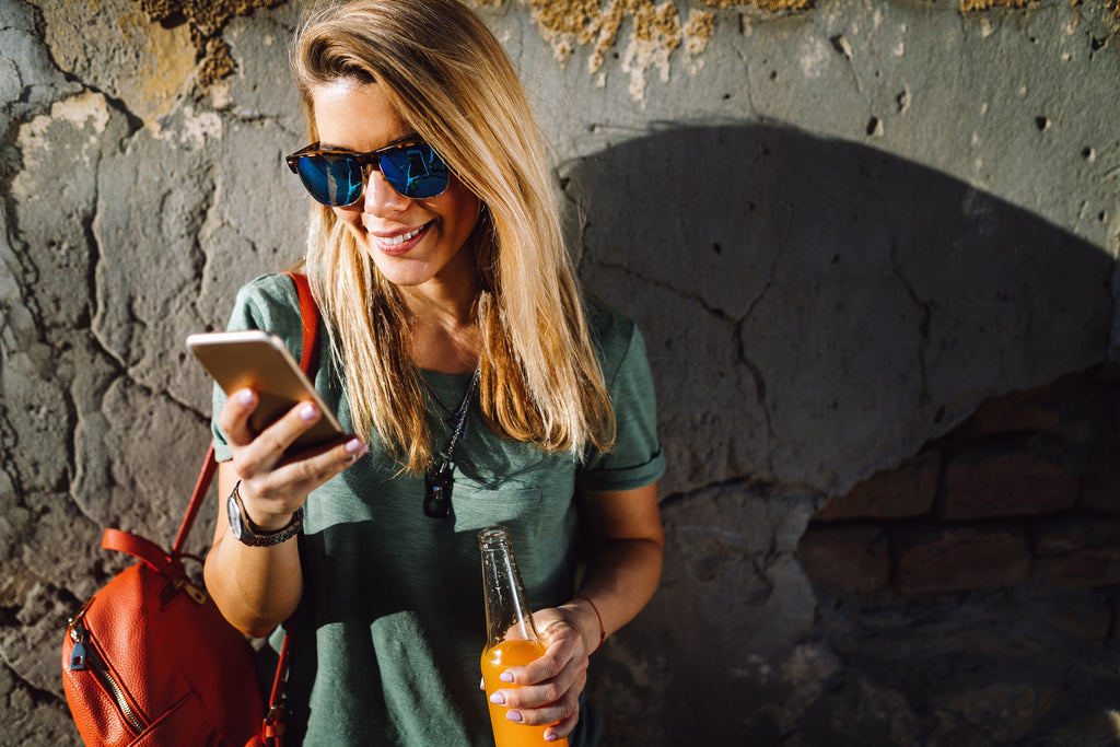 BLond woman in causal t-shirt looking down at iPhone 