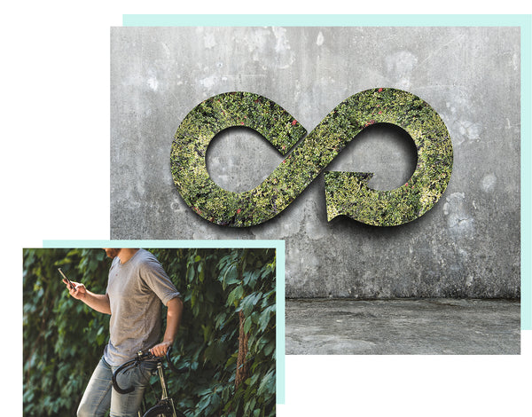 man texting while leaning on a bike with an infinity sign on green wall