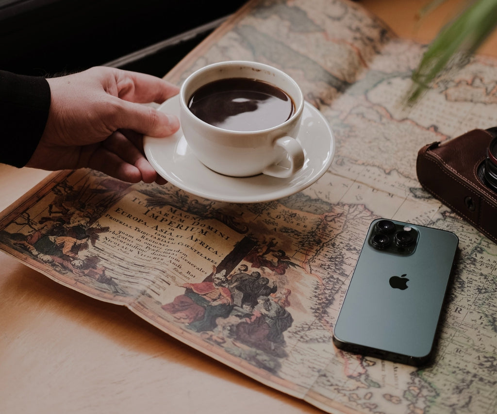 The Frank Mobile Blog Featuring a Midnight Green iPhone on a Tabletop With a Vintage Paper Map and Cup of Coffee