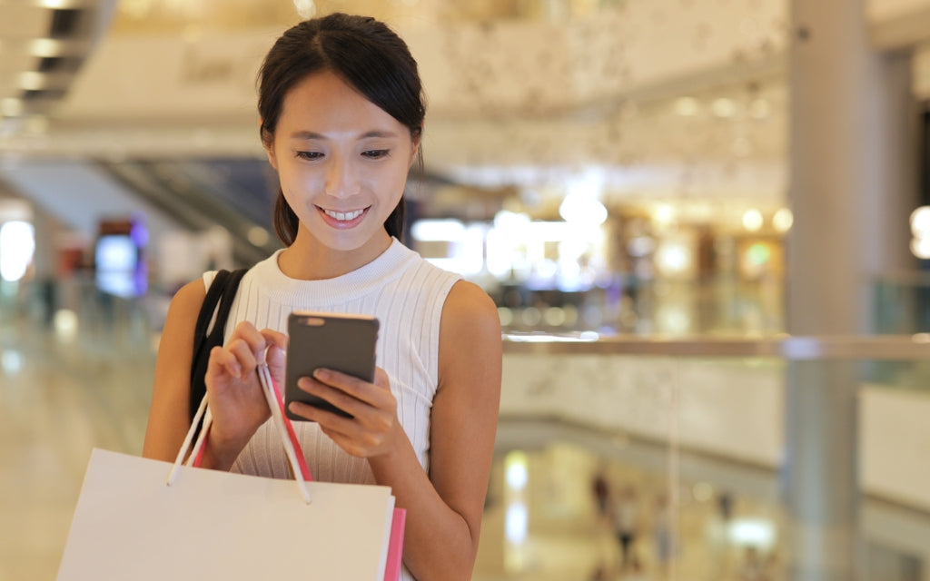 Woman on Smartphone in Shopping Mall - Frank Mobile Australia Blog