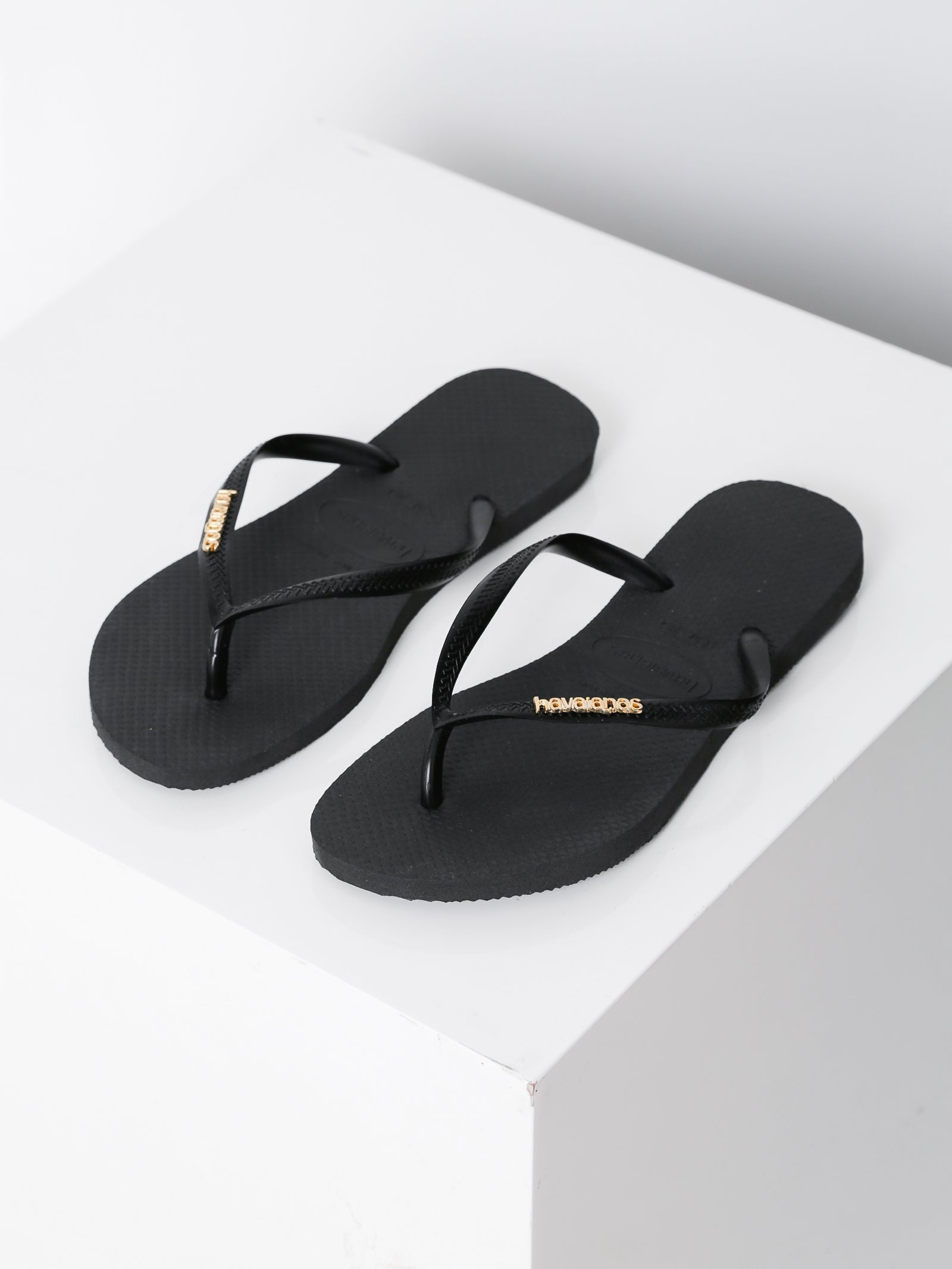 black slim havaianas with gold logo