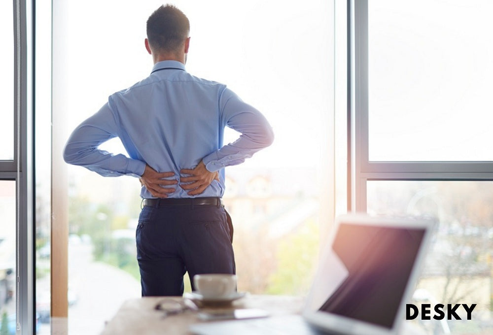 Businessman experiencing back pain in his office