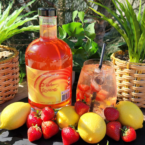 Newy Distillery Strawberry Limoncello Liqueur. 700ml bottle displayed next to Strawberry Limoncello Liqueur cocktail, surrounded by lemons and strawberries.
