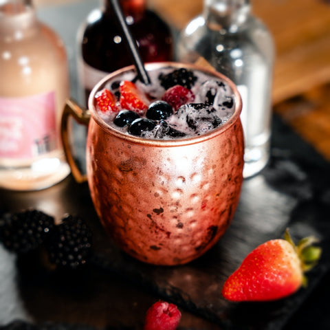 Bramble Fizz Gin Cocktail - Served in copper moscow mule mug, with wild berries garnish. Berry Pink Gin, Blackberry Liqueur by Newy Distillery.