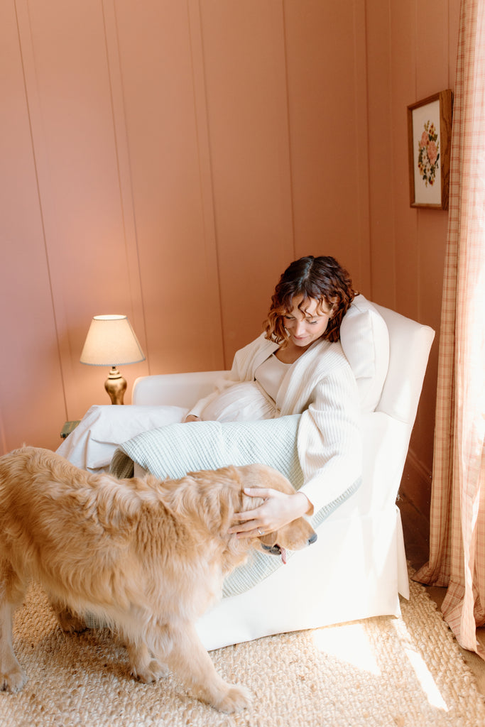 woman in glider petting dog