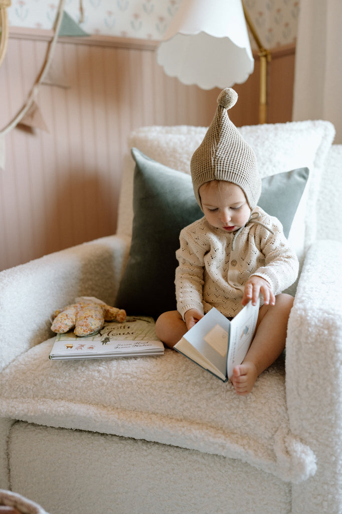 toddler reading book in recliner with faux mohair pillow