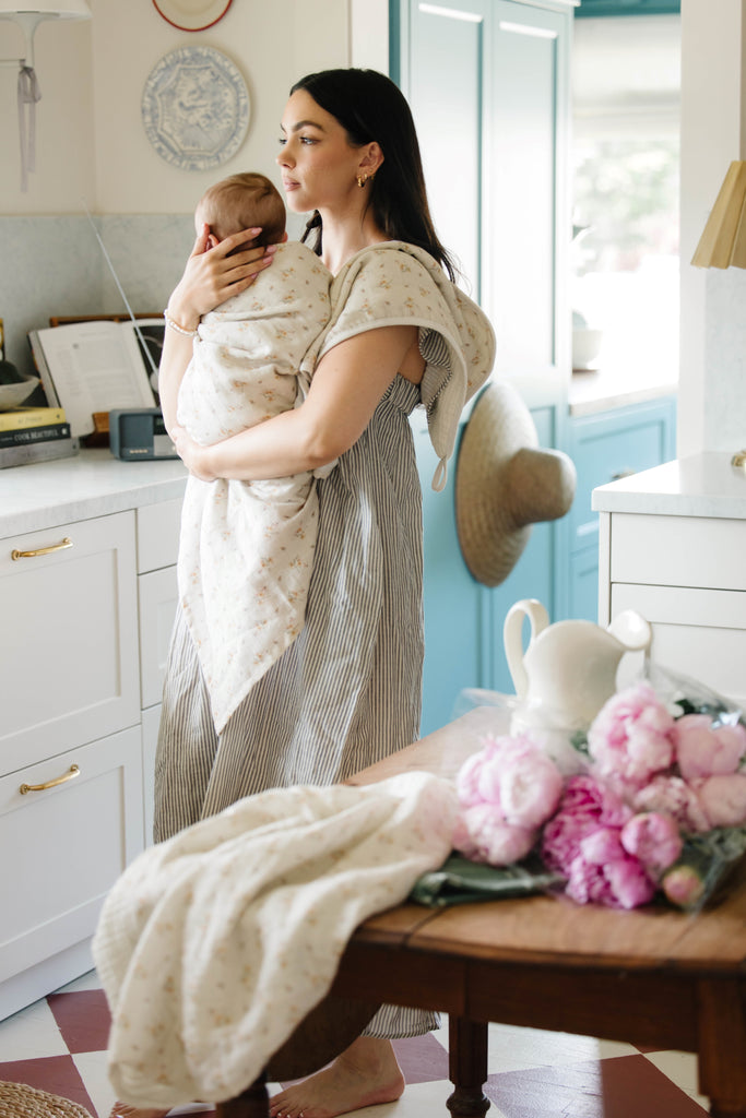 woman standing holding baby in eclectic kitchen