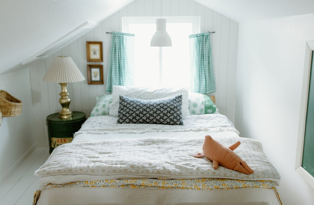 vintage bedroom ideas with floral blankets and pig stuffed animals