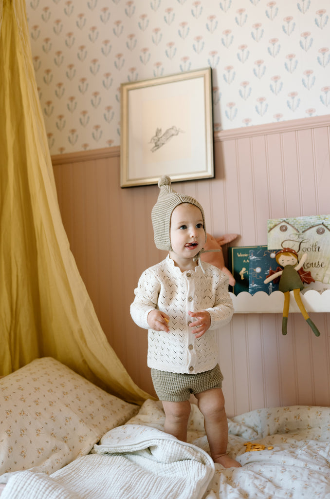 toddler standing on bed in Dusty Rose nursery