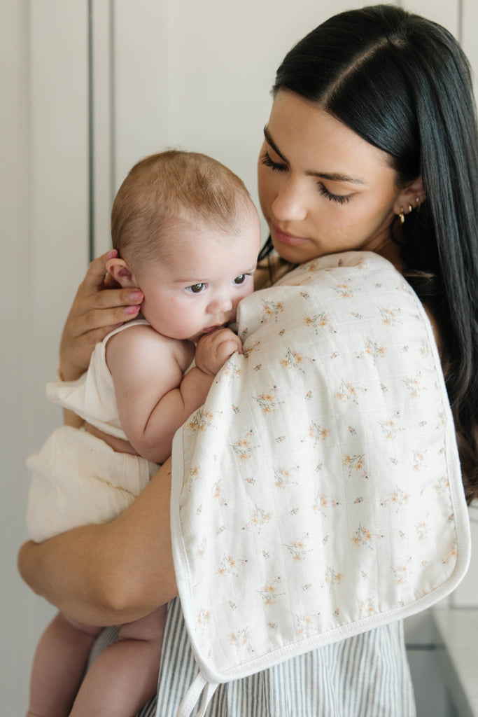 baby on shoulder of mom with Oilo ditsy floral swaddle blanket