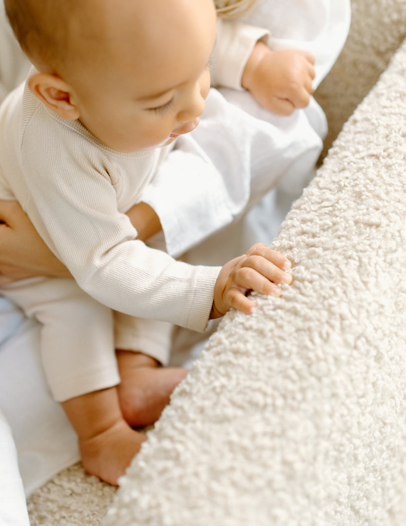 baby touching arm rest of Oilo Flynn recliner