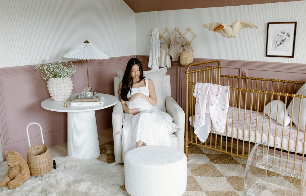 mauve nursery ideas with crib, glider and ottoman, side table and art