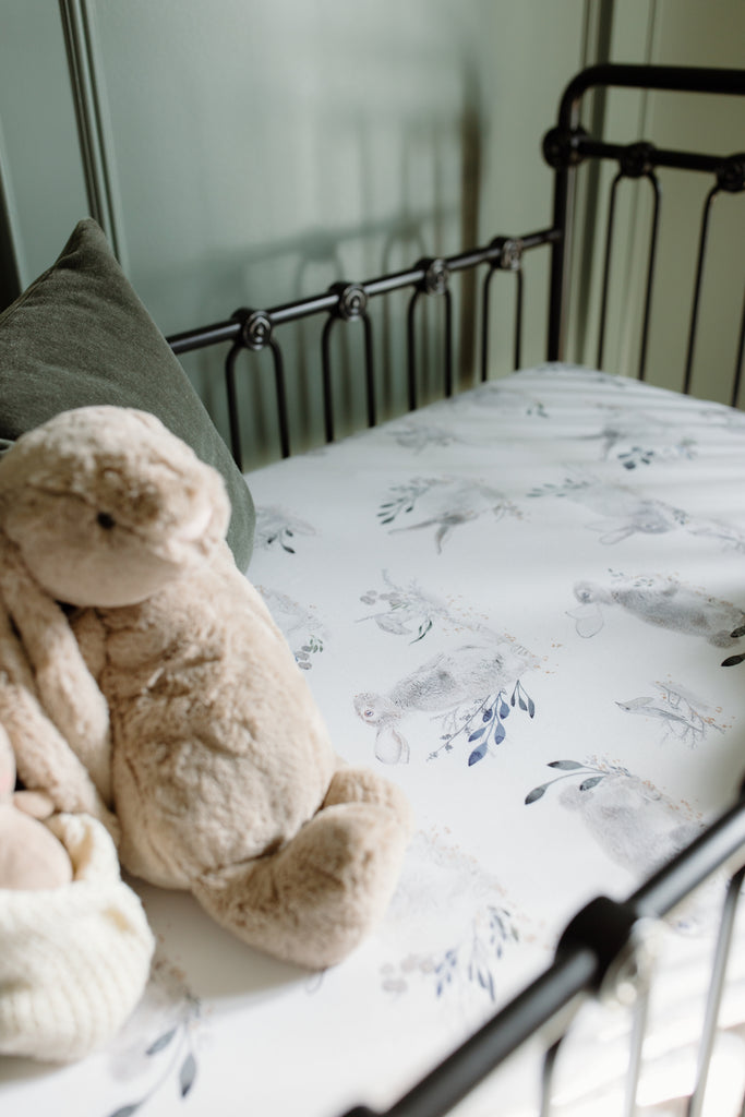 black crib with cottontail crib sheet and stuffed animal rabbit
