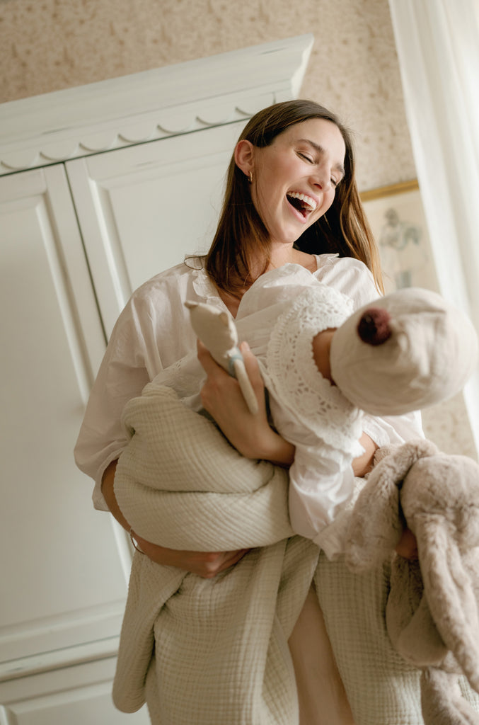 mother laughing holding baby in arms