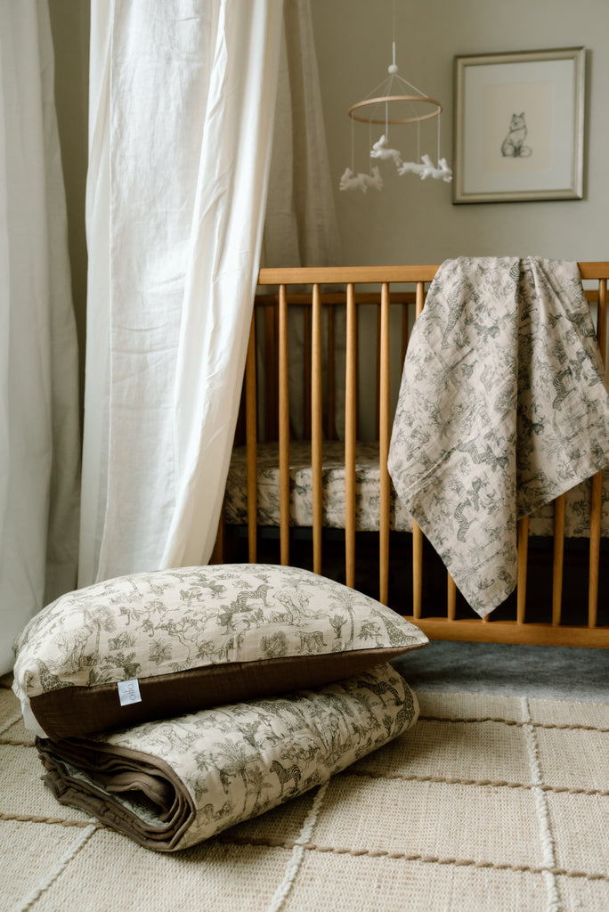 oilo nursery in safari theme with crib and quilt