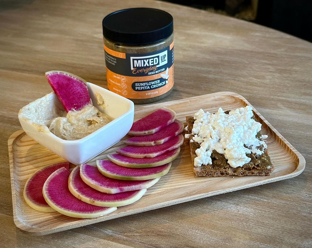 Sunflower Pepita Crunch Butter on crispbread mixed with watermelon radish and hummus