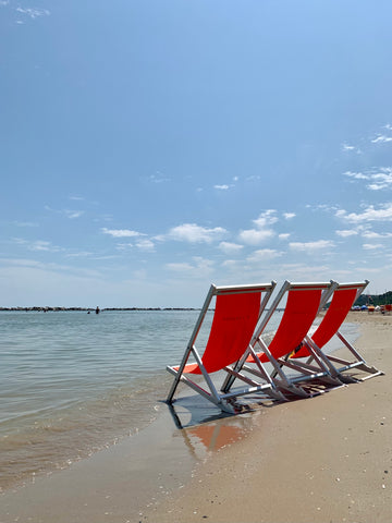 Italian beach with red deckchairs