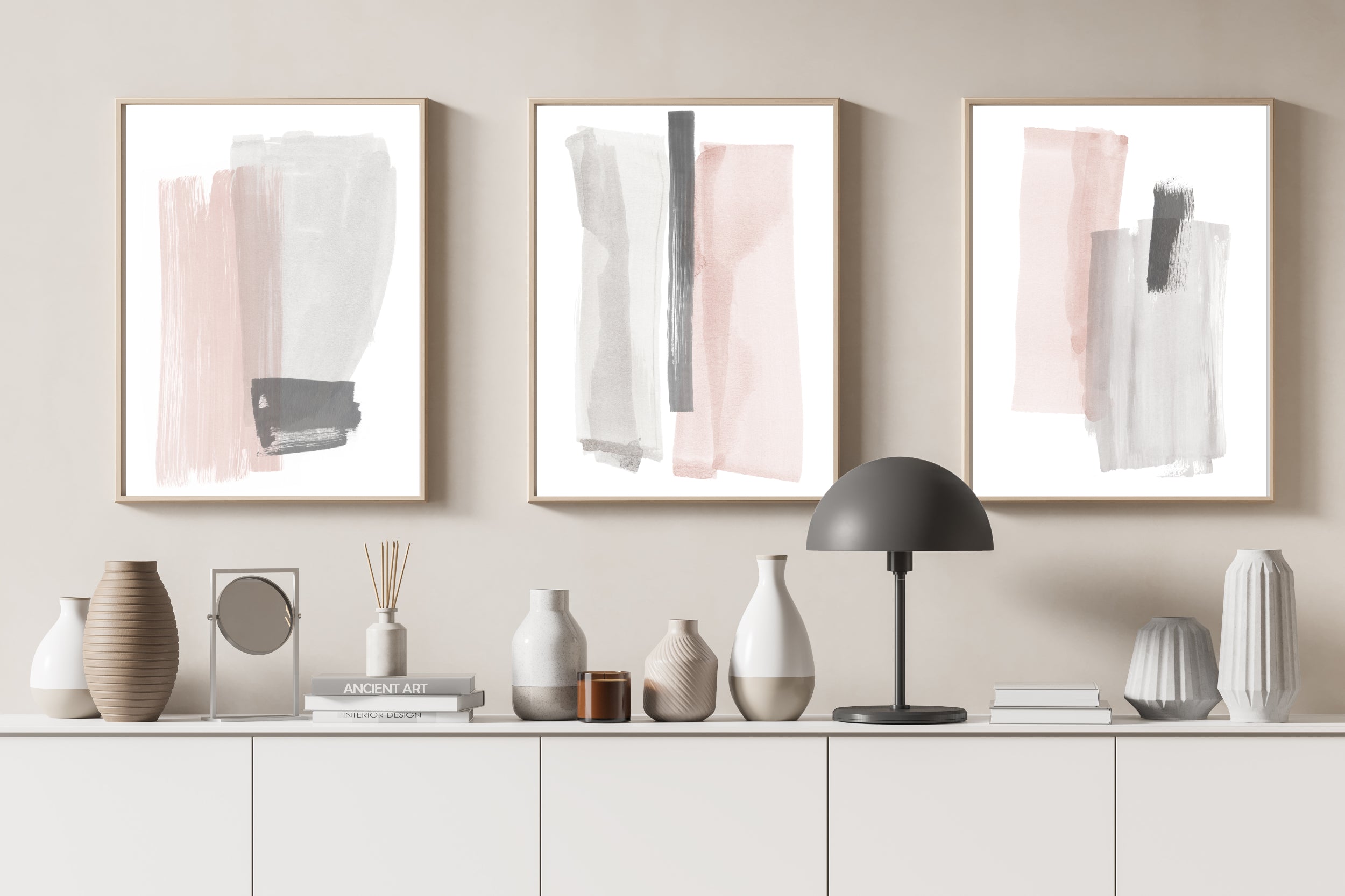 Set of three abstract prints in pink and grey against a neutral taupe background