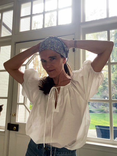 Ann at home in her new favorite peasant top: the Rosalina in white poplin. She paired it with jeans and a floral Anyway Scarf in her hair.
