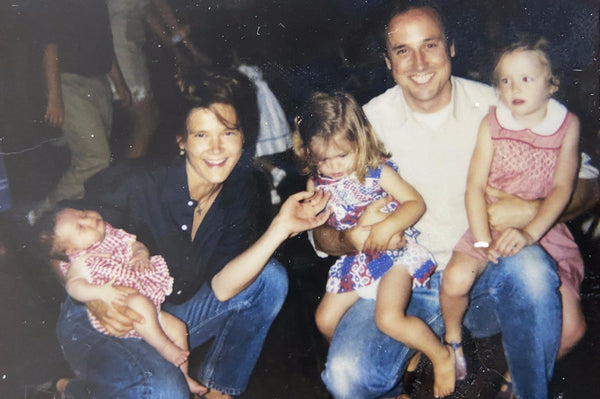 Ann and Sid with three of their daughters celebrating the Fourth of July. Ann is in a navy poplin button down, and Sid is in a white poplin shirt.