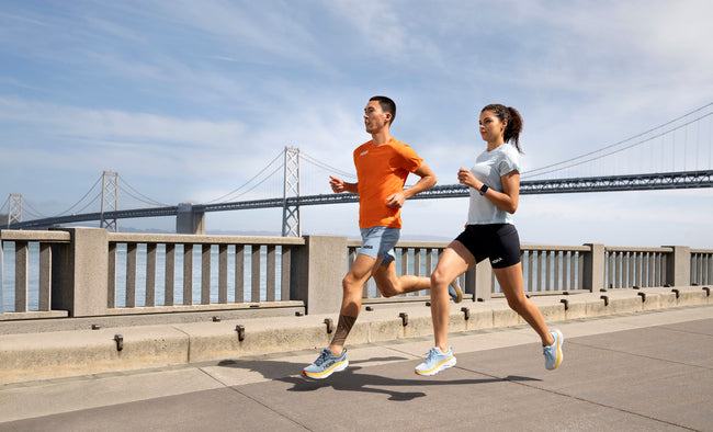 A man and woman jogging in their Bondi 8's from Shoe Mill.