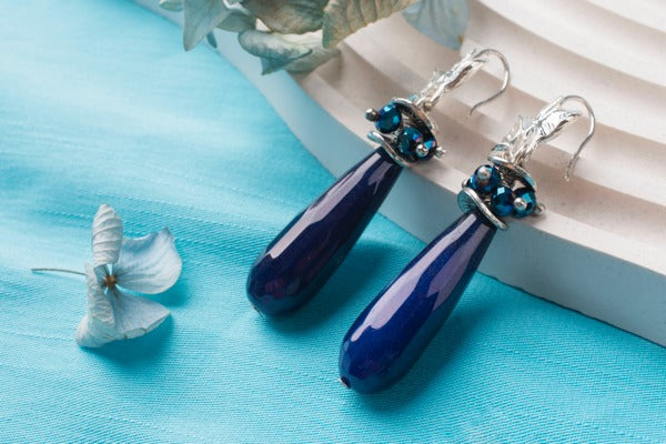 A pair of resin earrings with an opaque blue resin dye tint.
