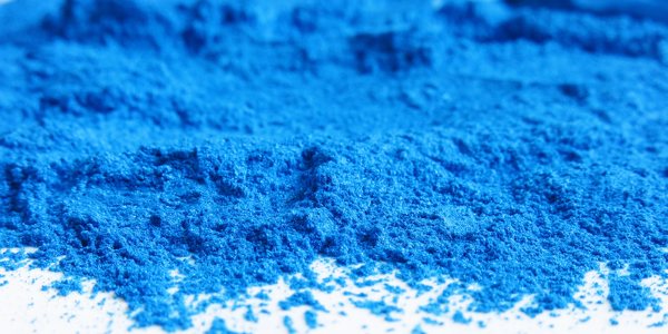 A mound of blue mica pigment on a white surface.