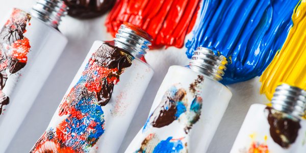 Several uncapped tubes of acrylic paint with thin stream of paint having been pressed from them.