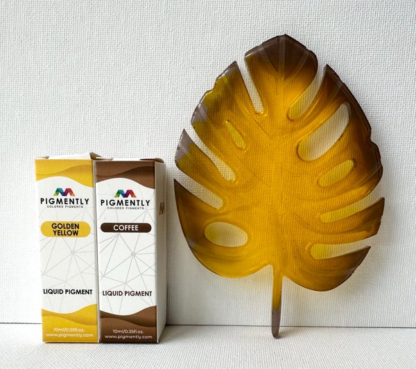 A leaf-shaped resin art piece, made using Pigmently's Coffee Liquid Dye and Golden Yellow Liquid Dye.