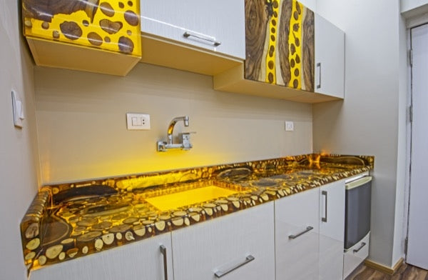 An epoxy resin countertop colored with a yellow mica powder, surrounded by ambient LED lighting.
