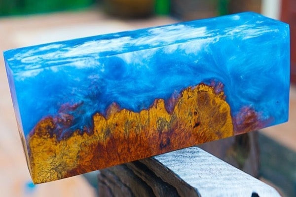 A block of wood and epoxy resin tinted with a blue mica powder pigment.