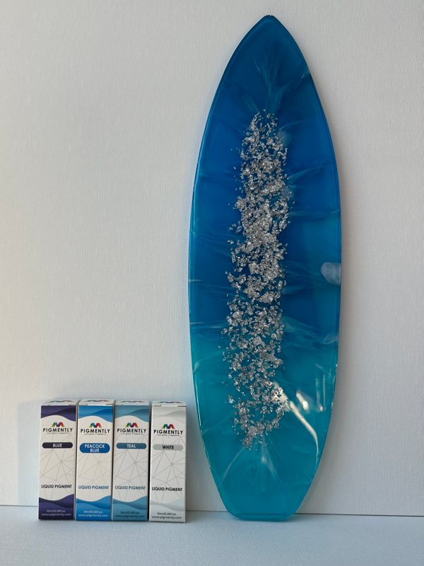 A surfboard-shaped resin piece made using Pigmently Liquid Dyes.