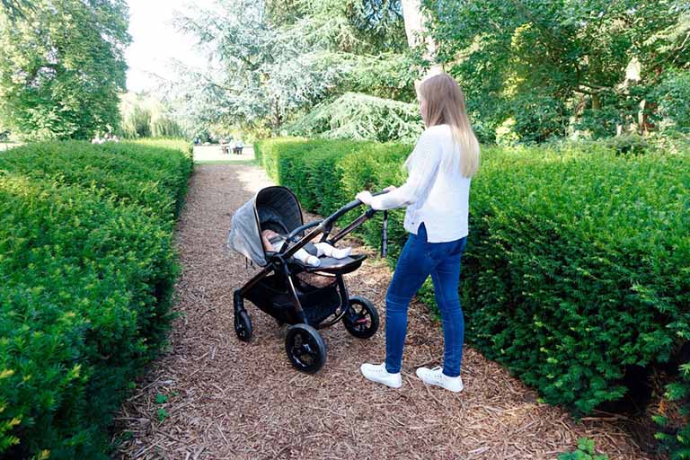 An image of Haley with the Ocarro pushchair, she is walking away from the camera with baby Elodie in the pushchair.