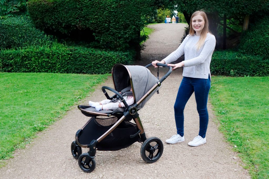 Haley is posing with the Ocarro pushchair, baby Elodie is in the forward-facing seat.