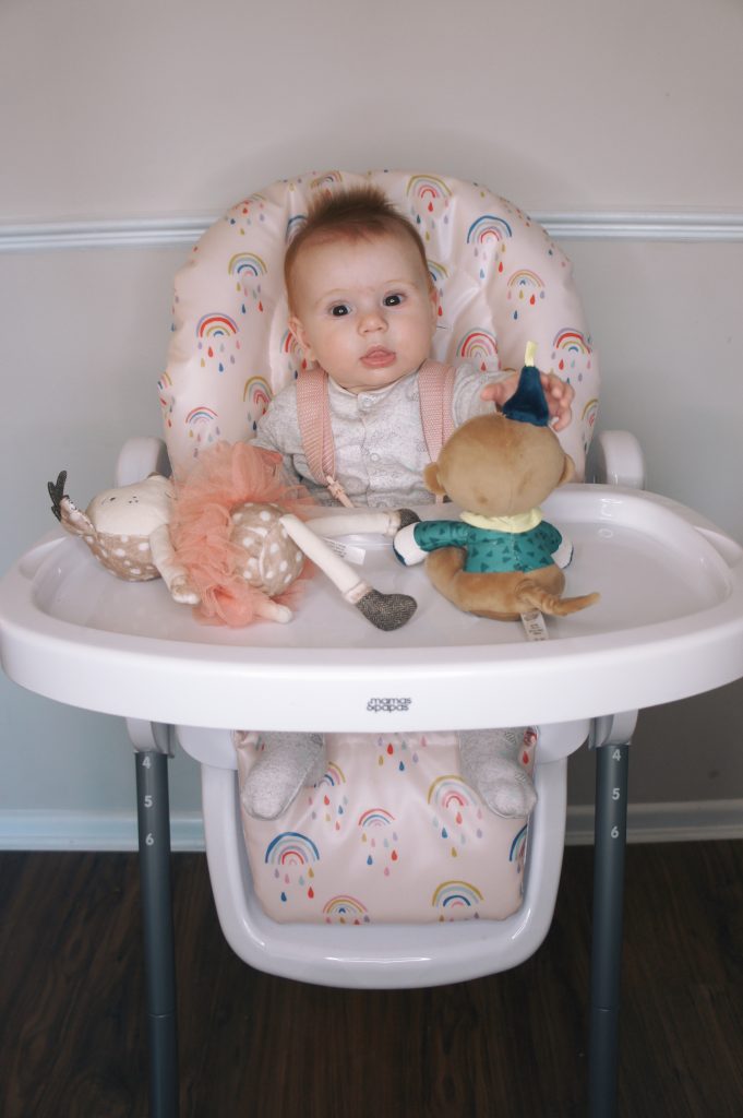 Posey sat in the Snax highchair with toys on the tray in front of her.