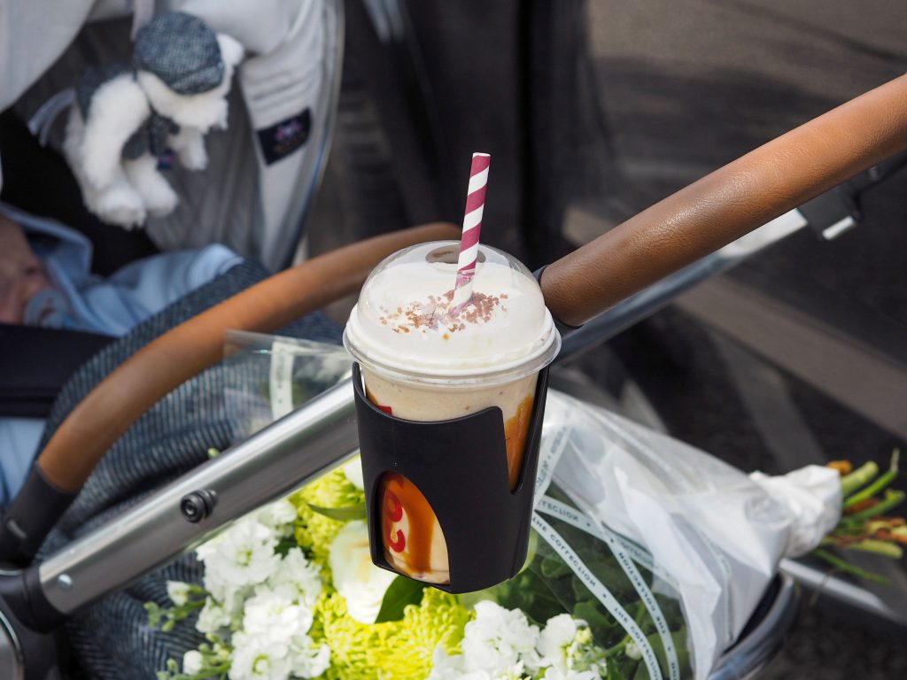 Close up of the Ocarro Moon pushchair's cup holder with an iced coffee inside.