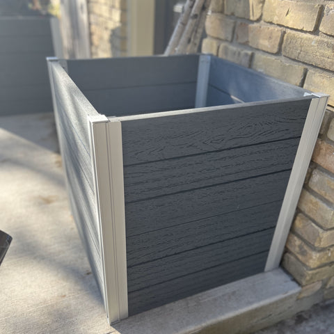 A grey vinyl planter box outside of a brick house