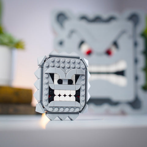 Mini Angry Block con Angry Block a grandezza naturale sullo sfondo, entrambi fatti di mattoncini LEGO®