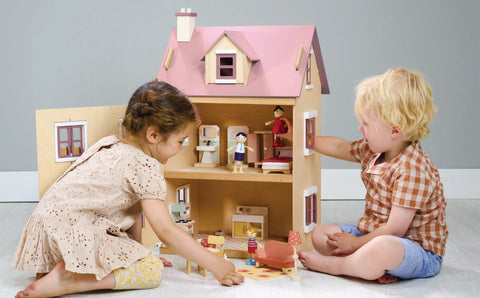 boy and girl playing with dolls house
