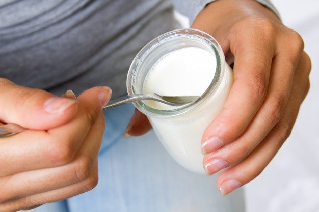 Close up of female eating yogurt Free Photo