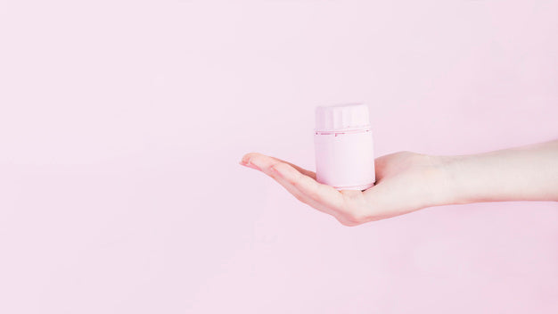 Human hand with bottle for medicine pills over pink background Free Photo