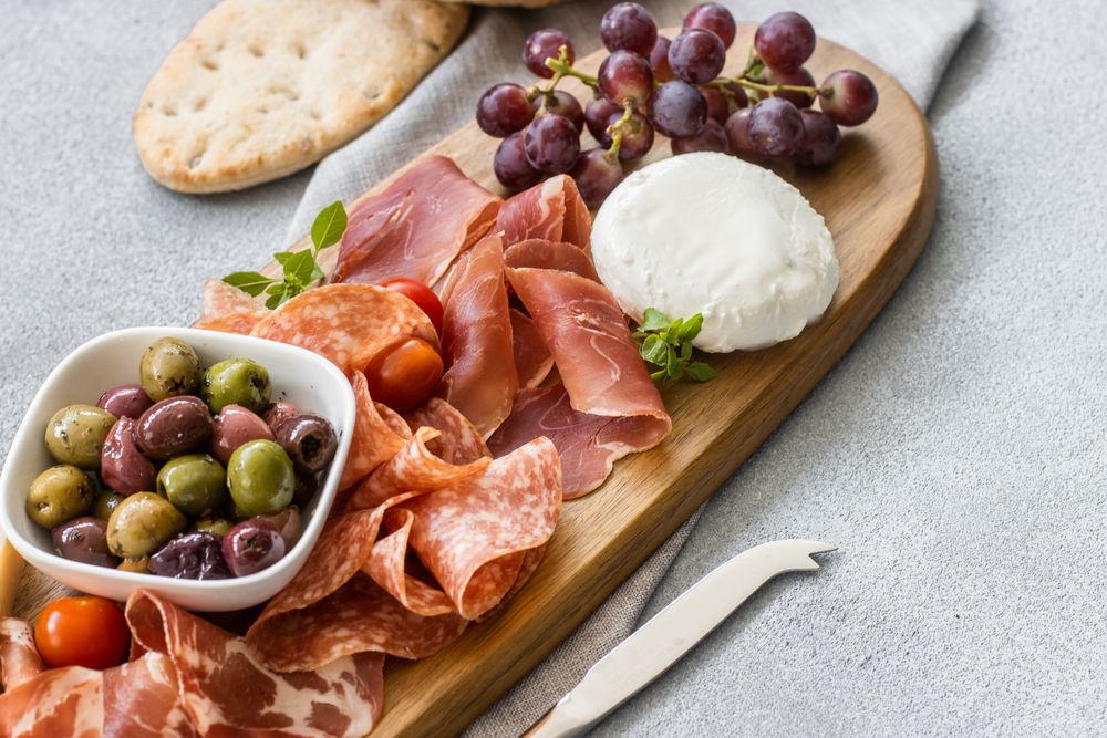 Cheese platter with cured meats and olives