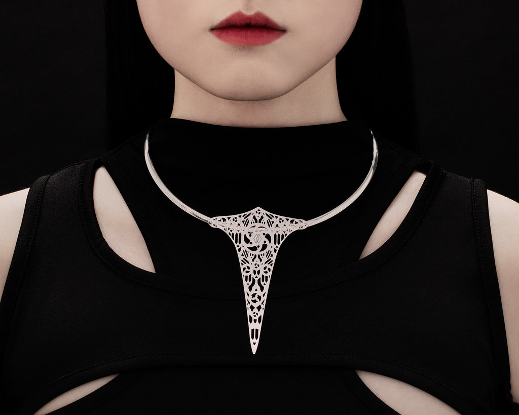 Elegant v-shaped rigid necklace with intricate filigree in the middle remembering gothic cathedral shapes and arches