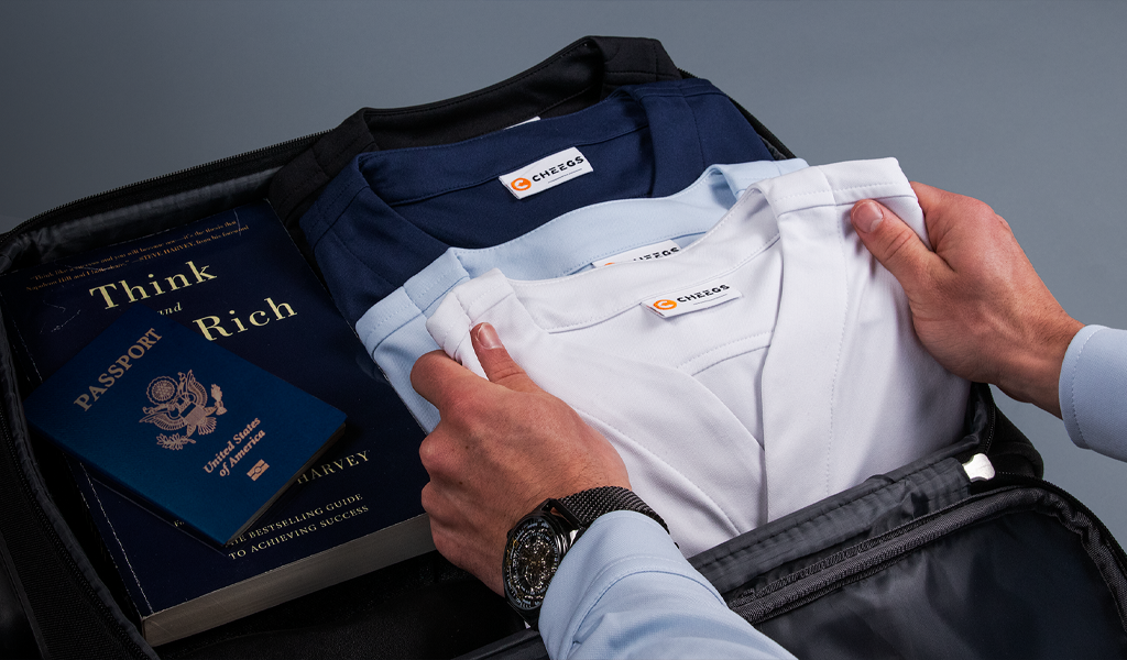 Man filling up his suitcase with Cheegs wrinkle-free Collarless Dress Shirts