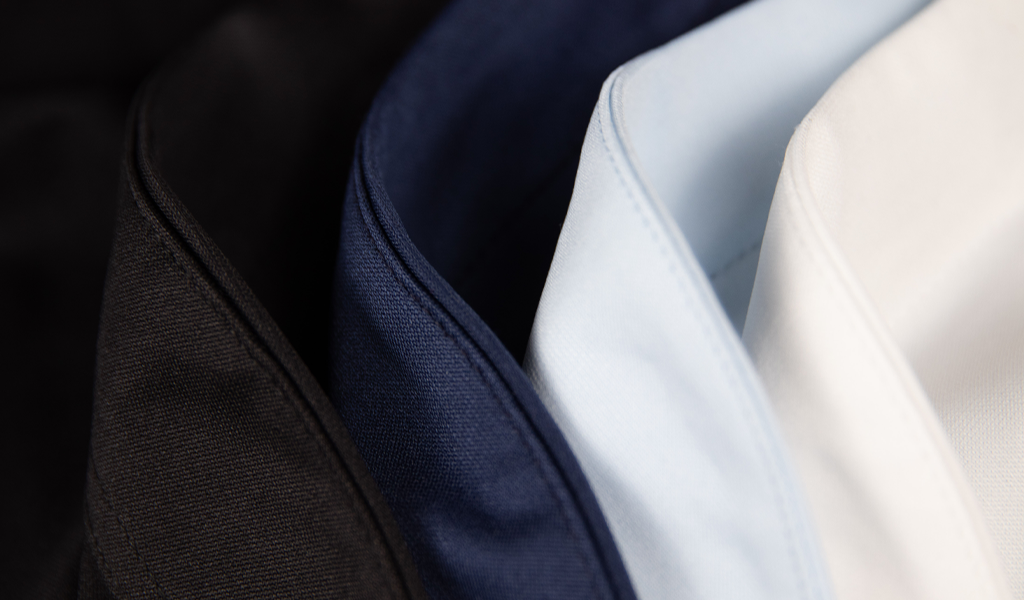 A close up of Cheegs collarless dress shirt's 4 main colors. Black, Navy, Light blue and White