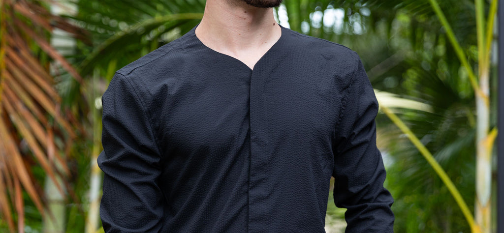 Man wearing Cheegs Collarless SeerTech™ Long Sleeve in Black in a tropical setting