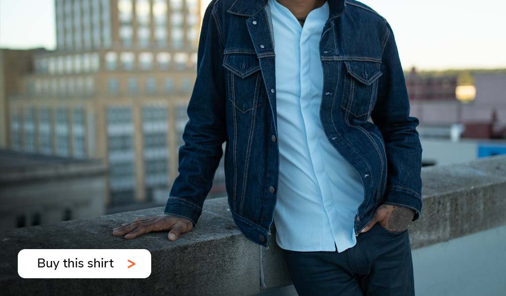 Man wearing a Cheegs collarless dress shirt 1.0 in light blue with jeans and a jeans jacket