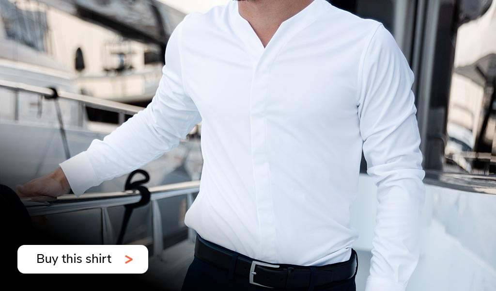 Close up of upper body of a business man on a yacht wearing a Cheegs collarless dress shirt in white.