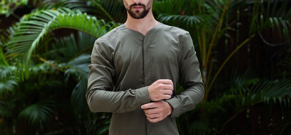 Man in tropical setting wearing a Cheegs Seersucker SeerTech Long Sleeve in Khaki