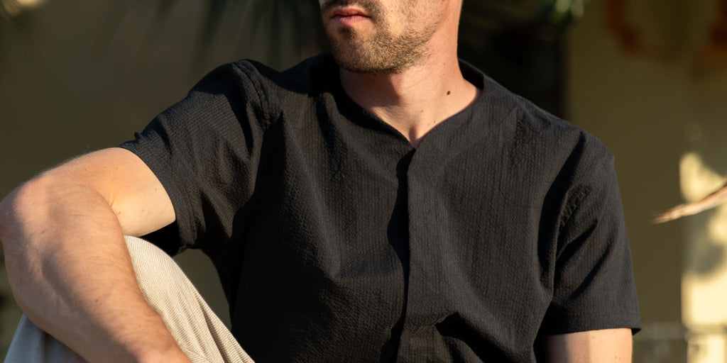 Close up of man wearing a Cheegs Collarless Future SeerTech short sleeve in black.